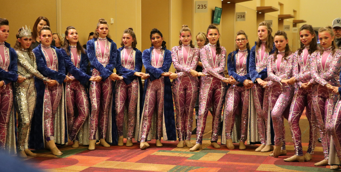 The Vision Dance Company circles up prior to a performance in Lucas Oil Stadium. Being named Grand National Champions has positively affected the entire school and community.