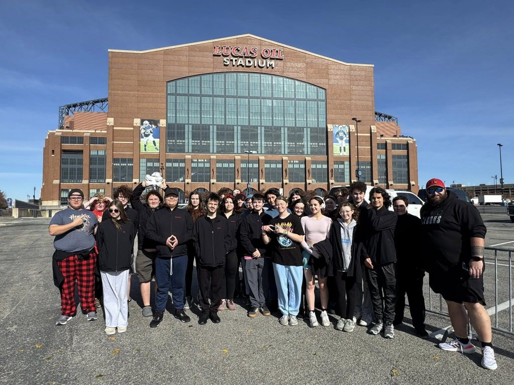 Students posing in front of Lucas Oil Stadium