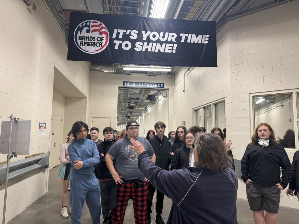Students touring a tunnel in Lucas Oil Stadium; a banner hung above them reads, "It's your time to shine!"