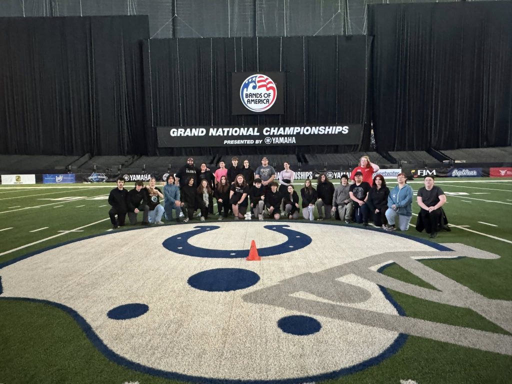 Students posing on the field at Lucas Oil Stadium