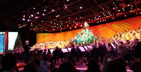 Wide shot image of entire stage performance of Disney's Candlelight processional featuring a mass choir and orchestra