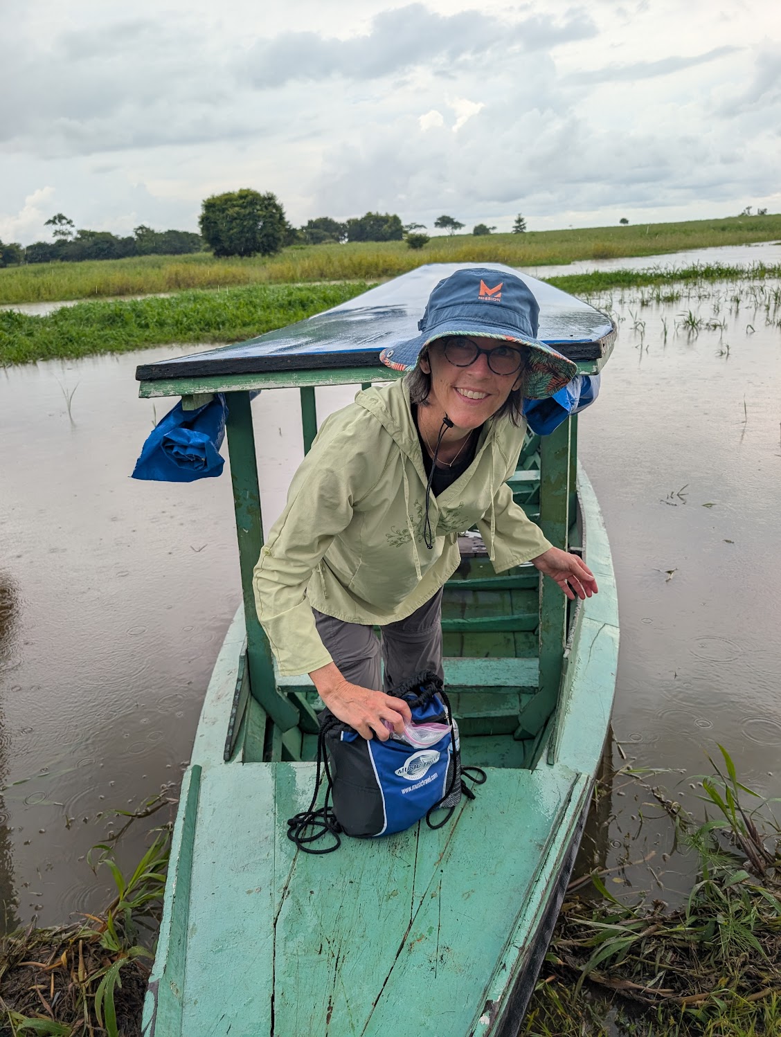Jen Shenberger smiling as she steps out of a small green boat