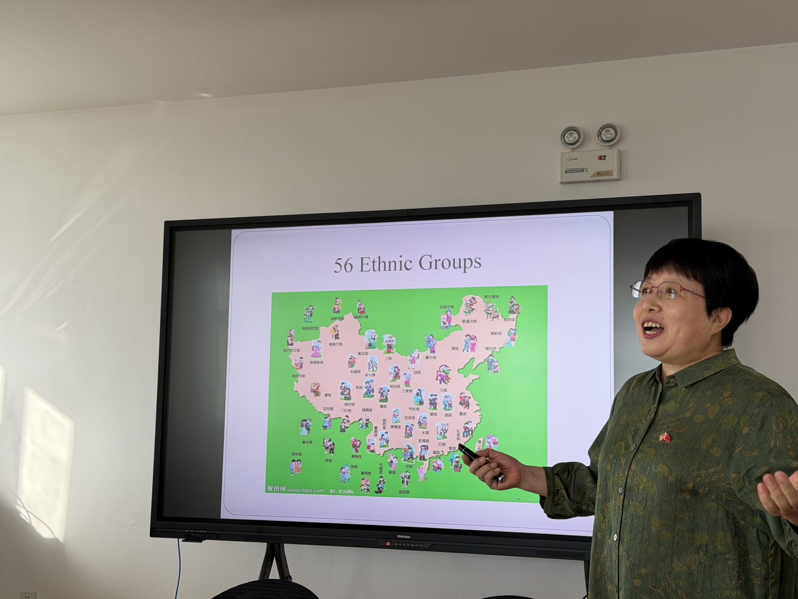 Woman giving a presentation; slide features a map and is titled "56 Ethnic Groups"