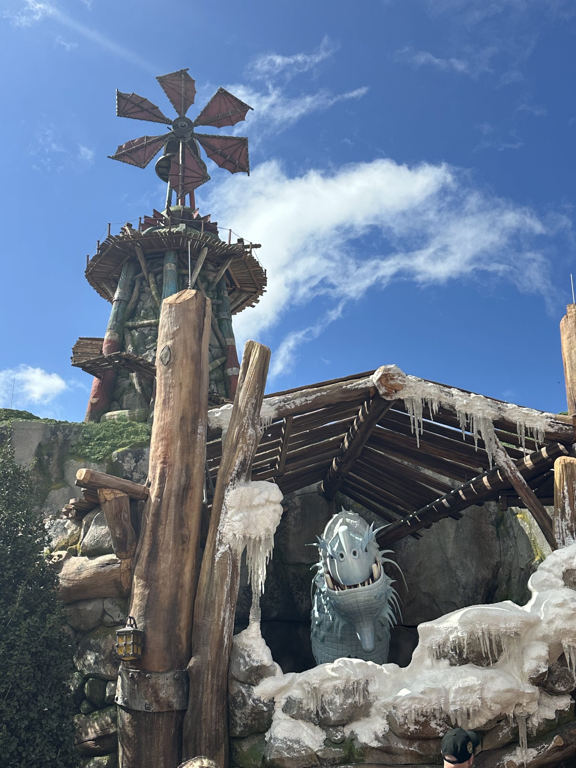 A dragon animatronic in an ice-covered log shelter at Universal Epic Universe