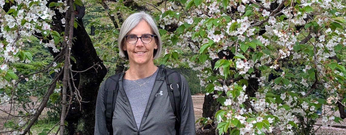Jen Shenberger smiling under a blossoming tree
