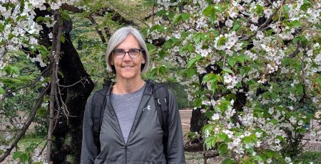 Jen Shenberger smiling under a blossoming tree